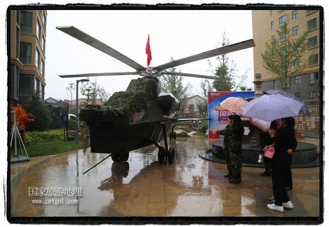 小區(qū)突然出現(xiàn)“飛機(jī)坦克”，其中殲15艦載戰(zhàn)斗機(jī)一架、99式主戰(zhàn)坦克一輛、武直-10武裝直升機(jī)一架，吸引了眾多市民雨中圍觀、合影。